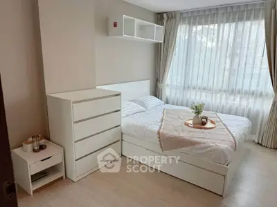 Bright and cozy bedroom with modern white furniture and large window.