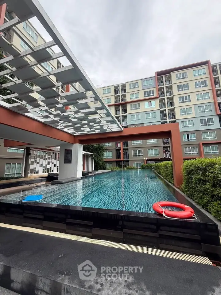 Modern apartment complex with stylish pool and contemporary architecture.