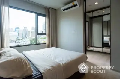 Modern bedroom with city view and mirrored wardrobe in high-rise apartment.