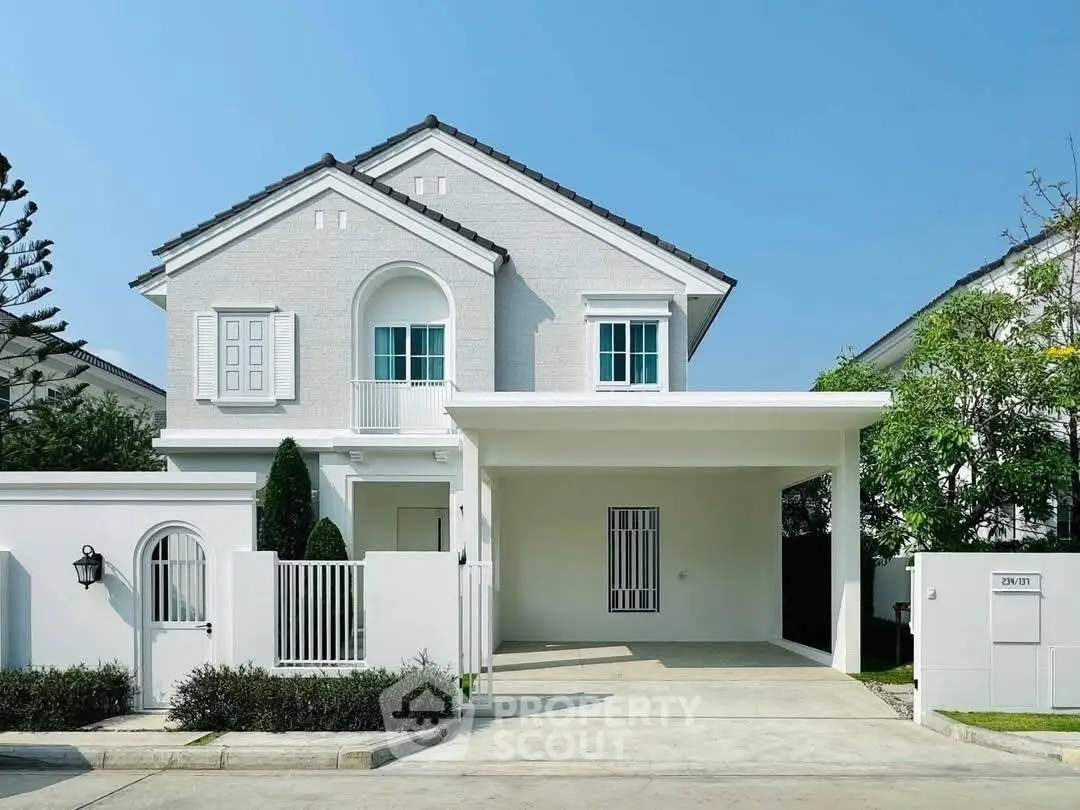 Charming white two-story house with modern design and spacious driveway.