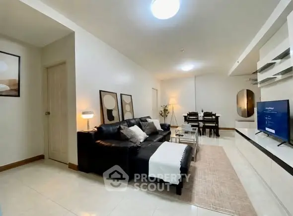 Spacious modern living room with sleek black sofa and elegant decor