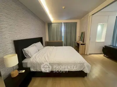 Spacious bedroom with modern decor and natural light, featuring a comfortable bed and stylish furnishings.