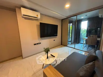Modern living room with air conditioning and large TV, featuring a cozy sofa and stylish decor.