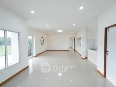 Spacious open-plan living area with large windows and balcony access