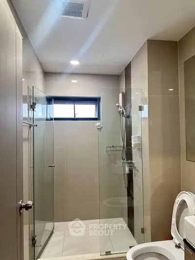 Modern bathroom with glass shower enclosure and sleek fixtures