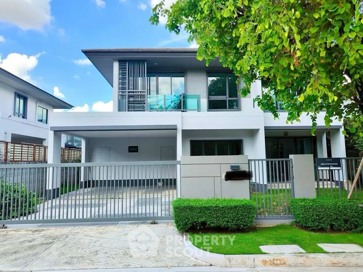 Modern two-story house with sleek design and lush greenery