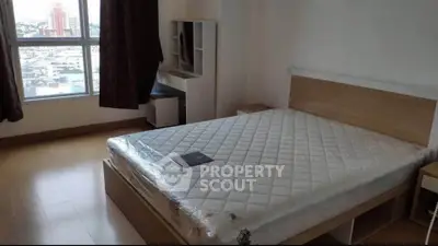 Spacious bedroom with large window offering city views, featuring a modern bed and sleek wooden flooring.