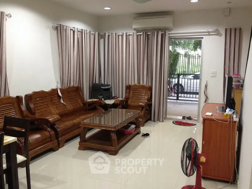Spacious living room with elegant wooden furniture and large windows for natural light.