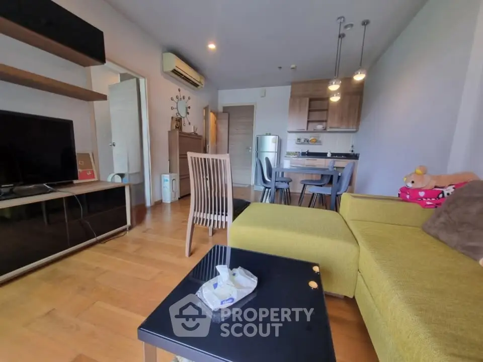 Modern living room with open kitchen, stylish furniture, and cozy ambiance in a contemporary apartment.