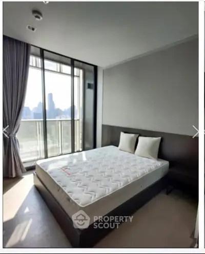 Modern bedroom with large window offering stunning city view, featuring a comfortable bed and elegant decor.