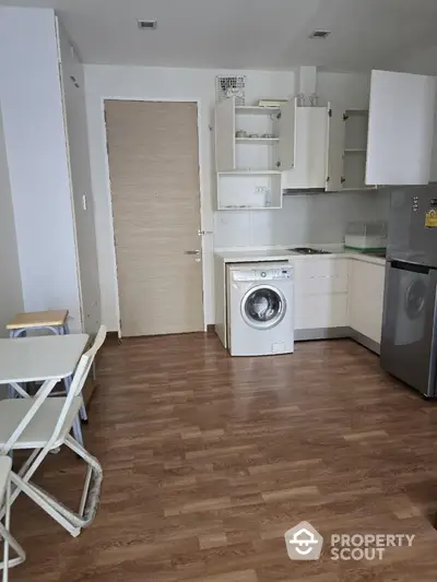 Modern kitchen with washing machine and sleek appliances in compact open layout