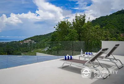 Stunning rooftop terrace with breathtaking mountain and ocean views, featuring modern sun loungers.