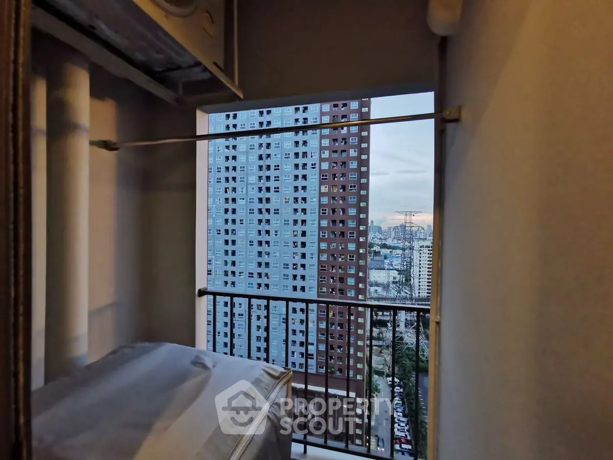 High-rise apartment view with cityscape from a balcony, showcasing urban living.