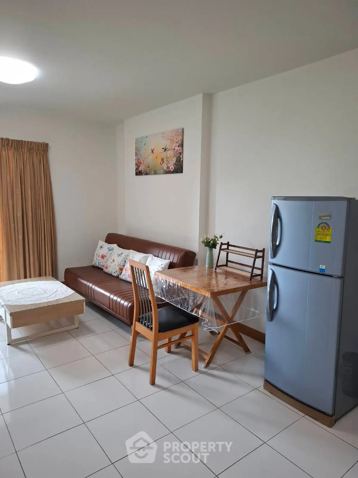 Cozy living room with modern furniture and kitchen area in open layout apartment.