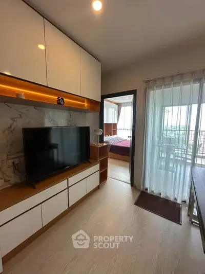 Modern living room with TV and balcony view in stylish apartment