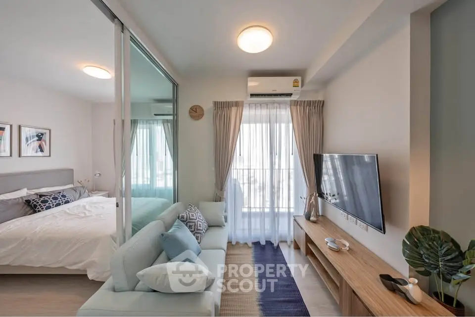 Modern studio apartment with cozy living area and stylish bedroom, featuring natural light and contemporary decor.
