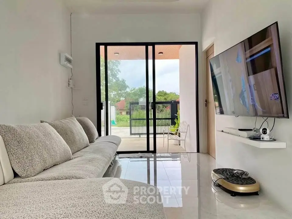 Modern living room with sleek design and large sliding glass doors opening to a garden view.