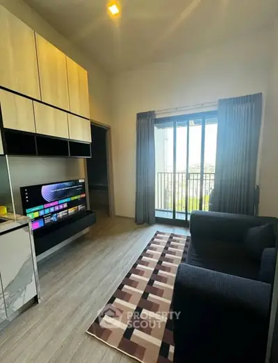 Modern living room with sleek design, featuring a large TV, stylish furniture, and a balcony view.