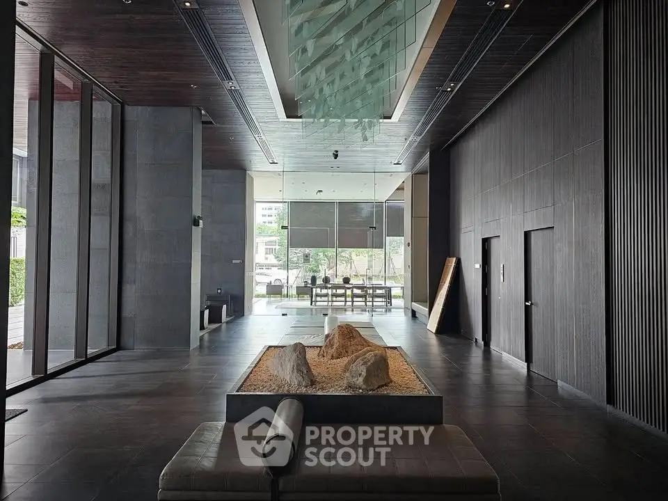 Luxurious modern building entrance with sleek design and natural elements, perfect for upscale living.