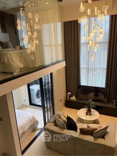 Luxurious modern duplex living room with elegant chandelier and mezzanine bedroom view.