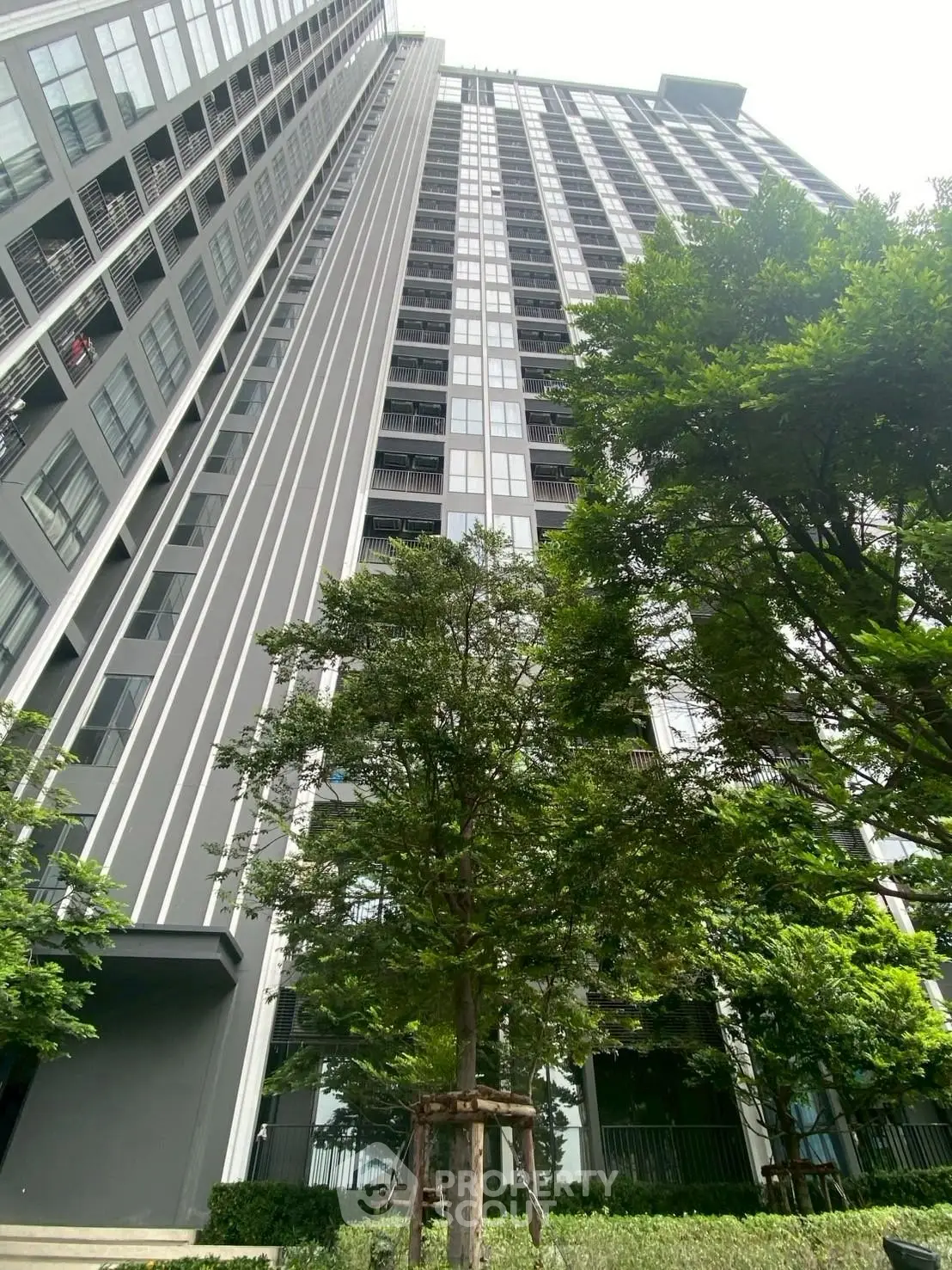 Modern high-rise building with lush greenery and sleek architectural design