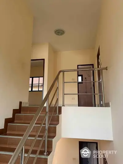 Modern staircase with sleek metal railing in a bright interior space