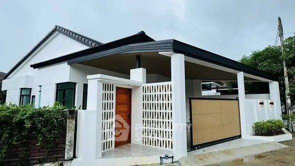 Modern single-story house with sleek design and spacious driveway in a serene neighborhood.