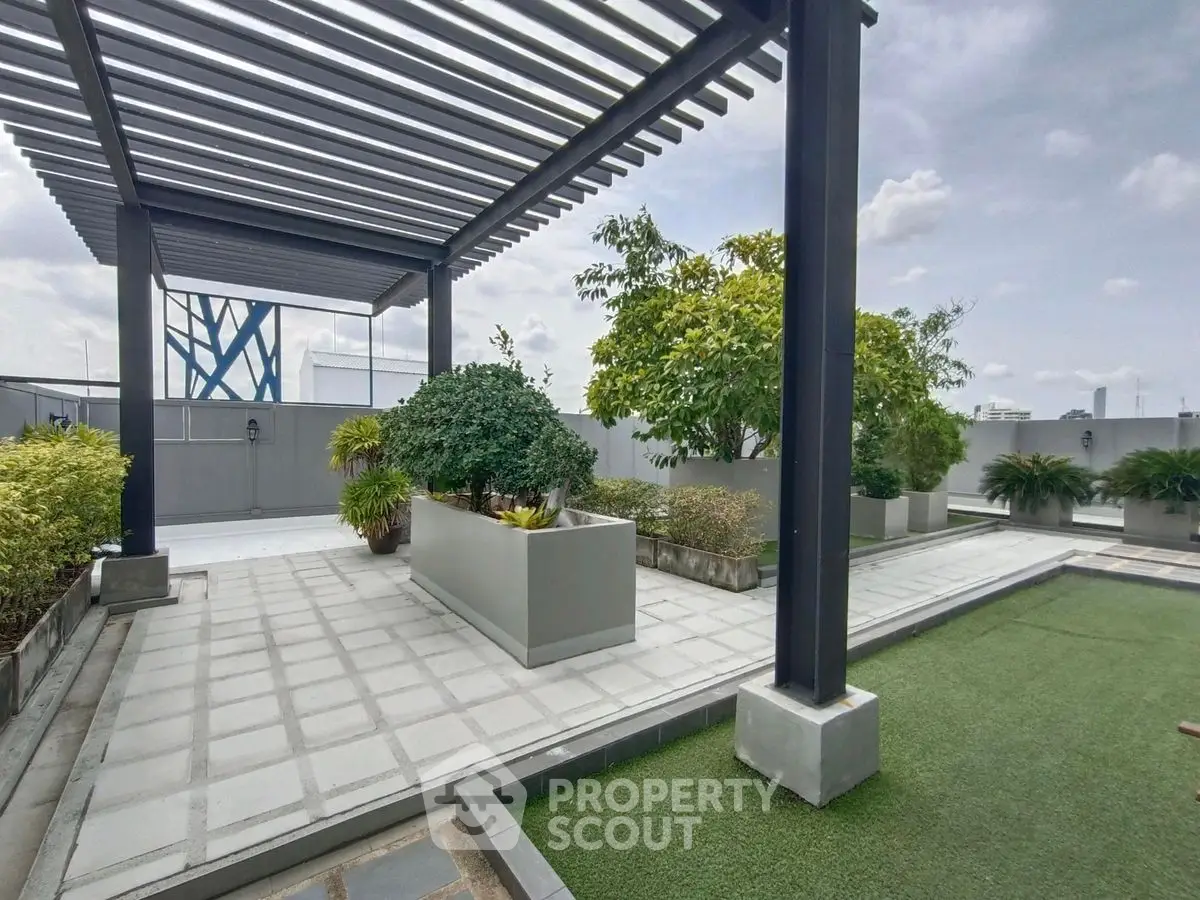 Modern rooftop garden with pergola and lush greenery, perfect for relaxation and city views.
