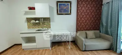 Chic studio apartment with modern kitchenette and cozy seating area, perfect for urban living.