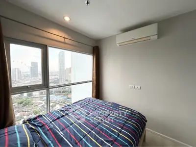 Modern bedroom with city view and air conditioning in high-rise apartment.