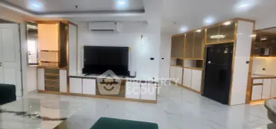 Luxurious modern living room with sleek design and high-end finishes, featuring a large TV and elegant cabinetry.