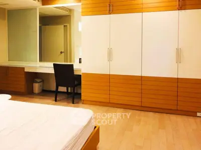 Spacious bedroom with modern wooden wardrobe and cozy study area.