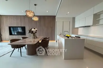 Luxurious modern kitchen with sleek design and elegant dining area in open layout.