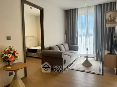 Modern living room with cozy sofa, elegant decor, and natural light from large window.