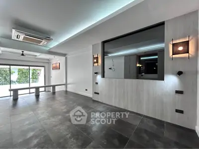 Spacious modern living room with large windows and stylish lighting, perfect for contemporary living.