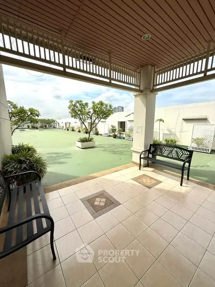 Spacious rooftop garden with seating area and lush greenery, perfect for relaxation and leisure.