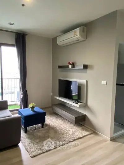 Modern living room with sleek TV setup and air conditioning, featuring a cozy rug and stylish decor.