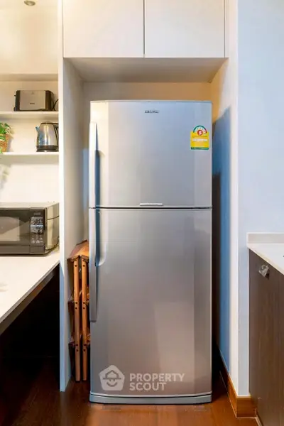 Modern kitchen with sleek stainless steel refrigerator and appliances.