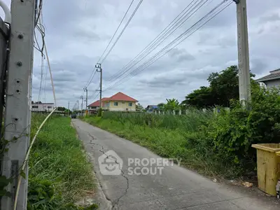 Charming suburban street with lush greenery and distant houses, perfect for peaceful living.