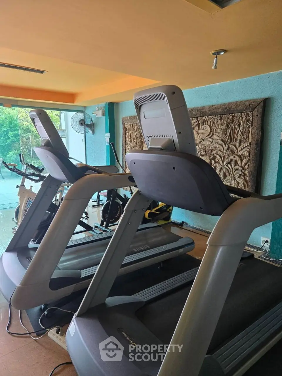 Modern gym with treadmills and decorative wall art in a bright fitness area.
