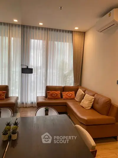 Stylish living room with modern furniture and large windows for natural light.