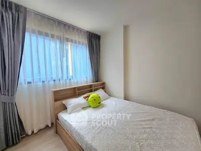 Cozy bedroom with natural light and modern decor, perfect for relaxation.