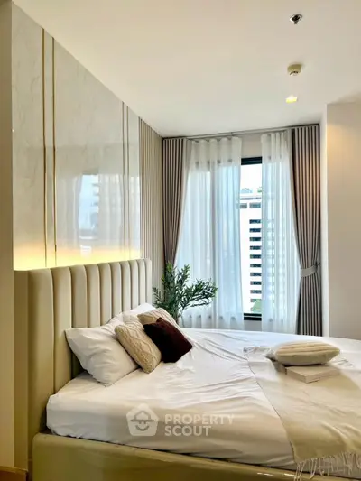 Luxurious bedroom with elegant decor and city view, featuring plush bedding and stylish curtains.