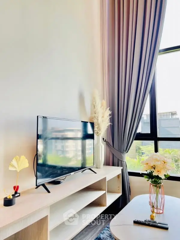 Stylish living room with modern TV setup and large window view