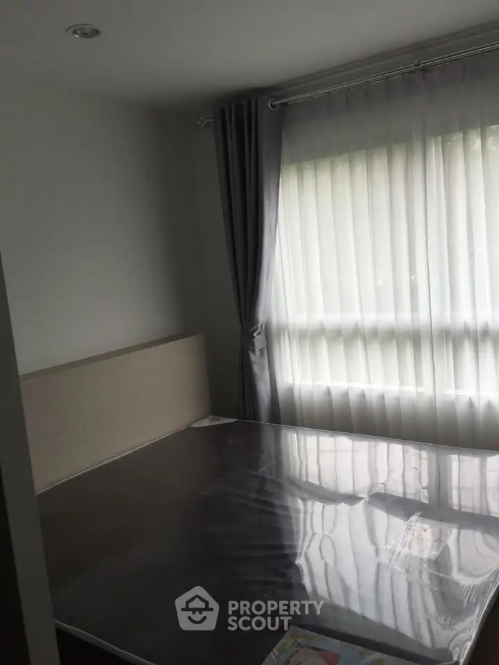 Cozy bedroom with large window and elegant curtains, perfect for natural light lovers.