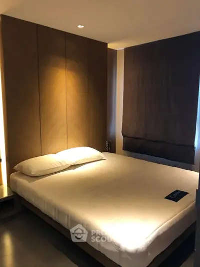Cozy bedroom with modern design and soft lighting, featuring a comfortable bed and elegant window treatment.