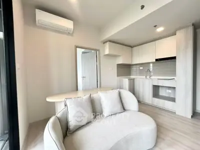 Modern open-layout living room with sleek kitchen and stylish furniture