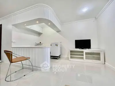 Modern minimalist living room with sleek white kitchen and stylish furniture