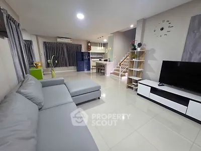 Spacious modern living room with sleek furniture and open kitchen layout