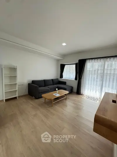 Spacious living room with modern furniture and large windows for natural light.